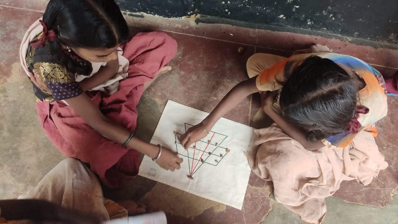 Children enjoying a game of Goat and Tiger