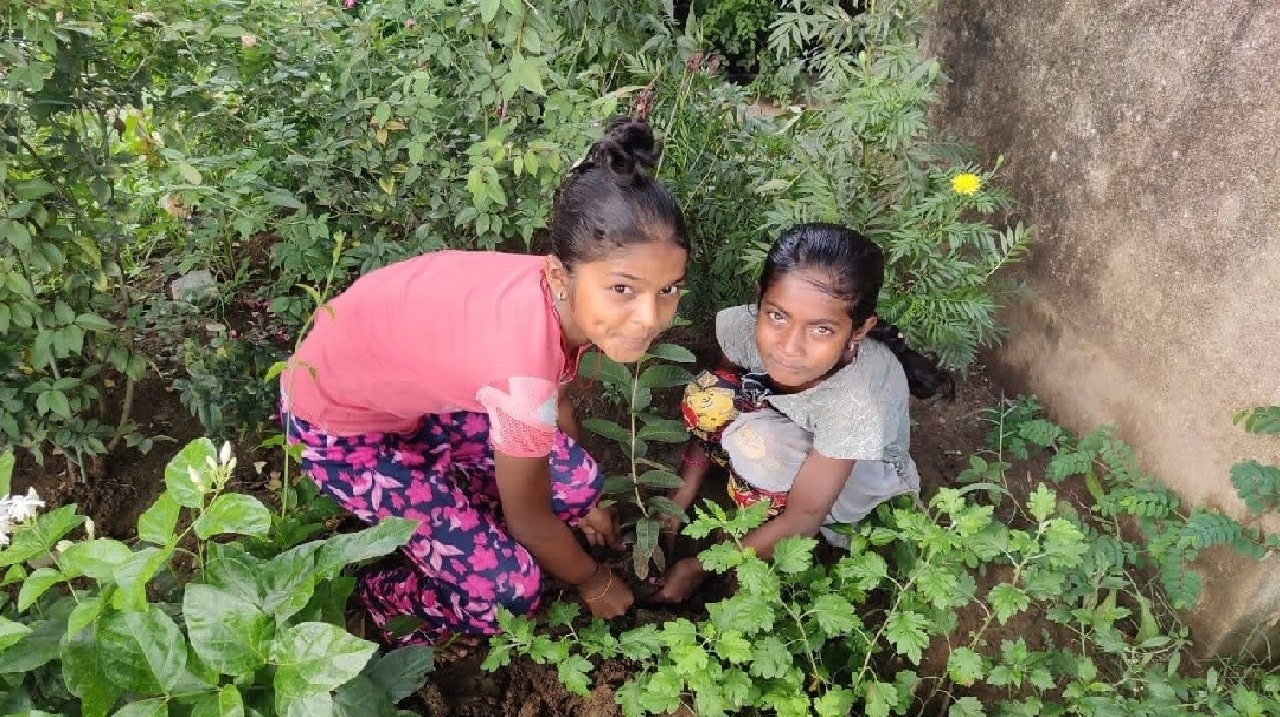 Girls planting sapling as a part of their experiential learning